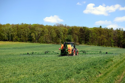 Oprysk pola uprawnego przy użyciu traktora