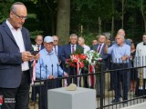 Daniel Offen, przewodniczący Związku Dębiczan w Izraelu odmawia modlitwę, stojąc przed zbiorową mogiłą. W tle uczestnicy uroczystości