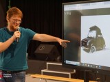Osoba w trakcie prezentacji multimedialnej wyświetlonej na monitorze