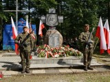 Żołnierze stoją przed pomnikiem